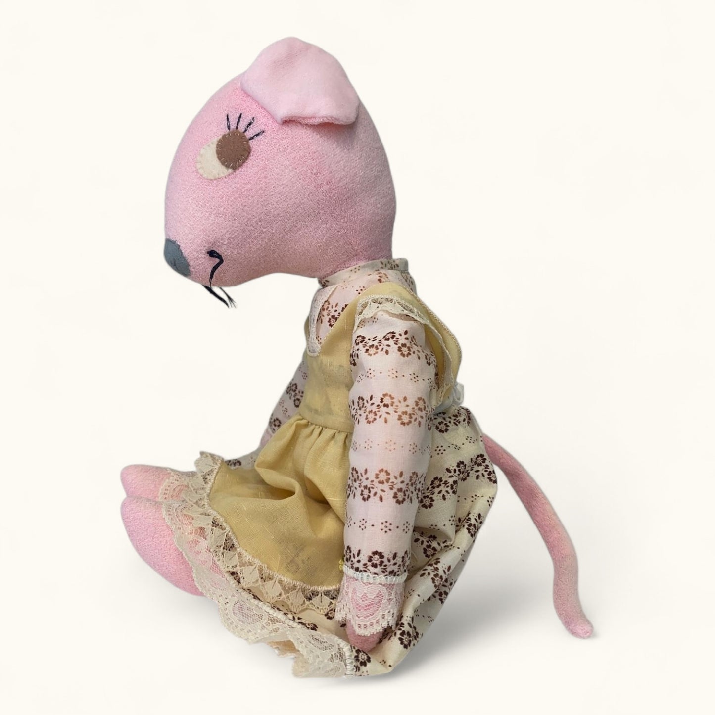 Stuffed mouse toy with a floral dress on a white background