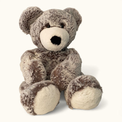 Plush teddy bear with brown fur and white paws on a white background