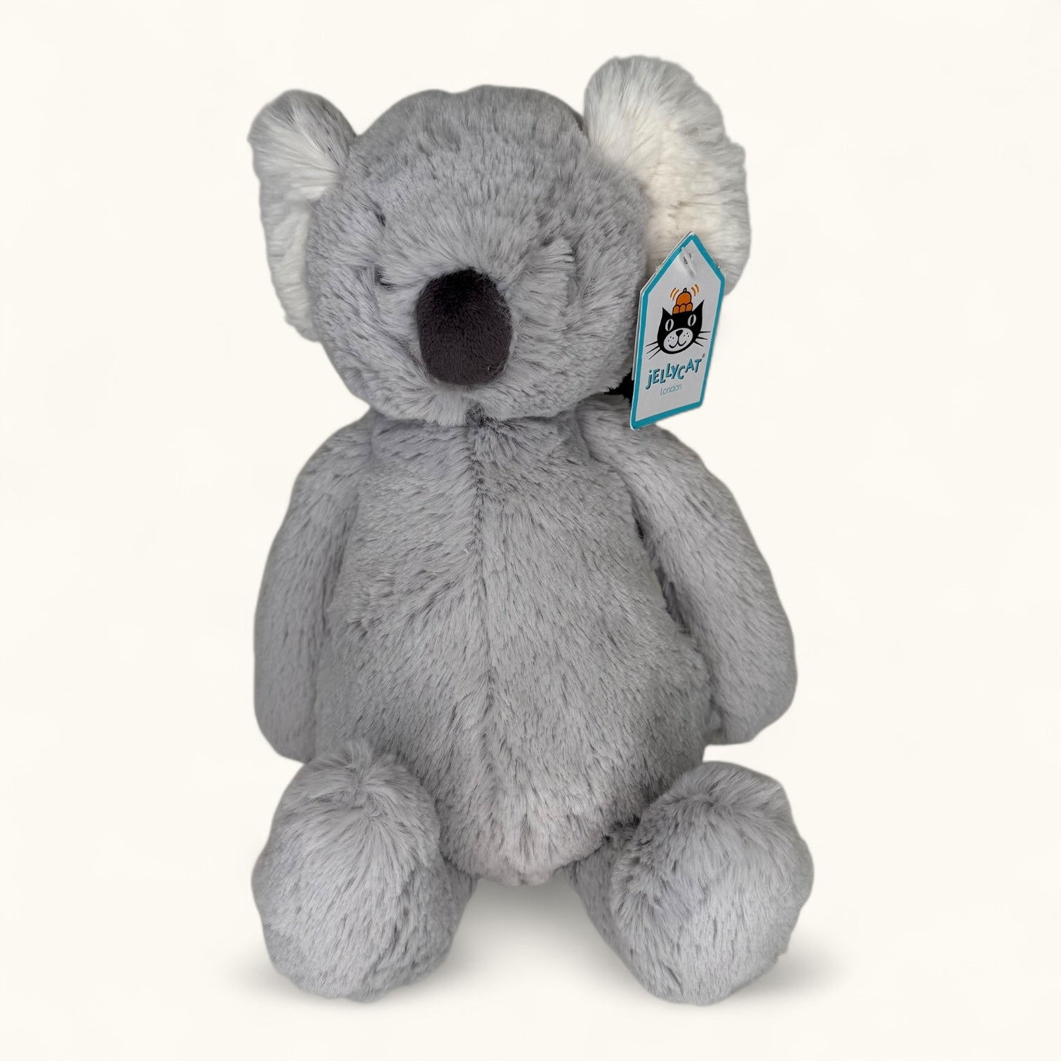 Gray plush koala toy with a visible brand tag on a white background