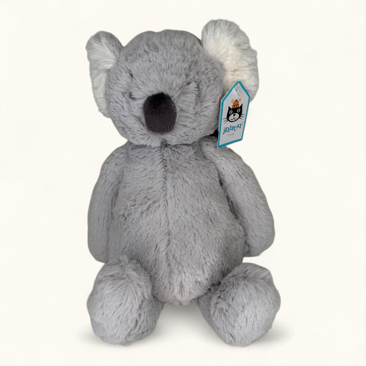 Gray plush koala toy with a visible brand tag on a white background