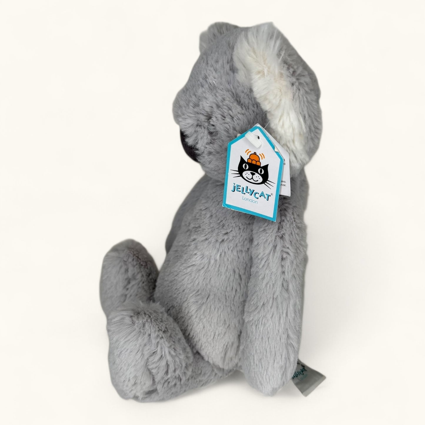 Gray plush toy with a Jellycat tag on a white background