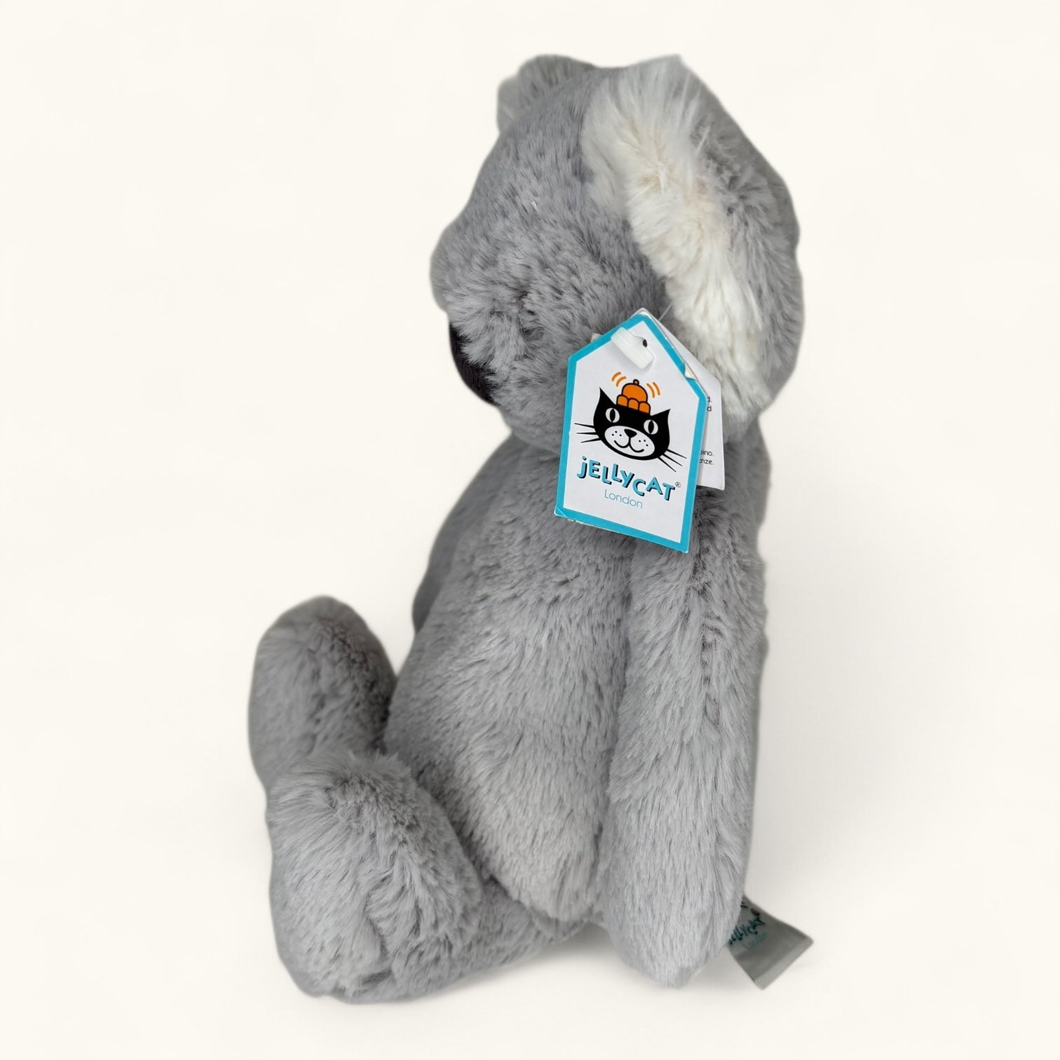 Gray plush toy with a Jellycat tag on a white background