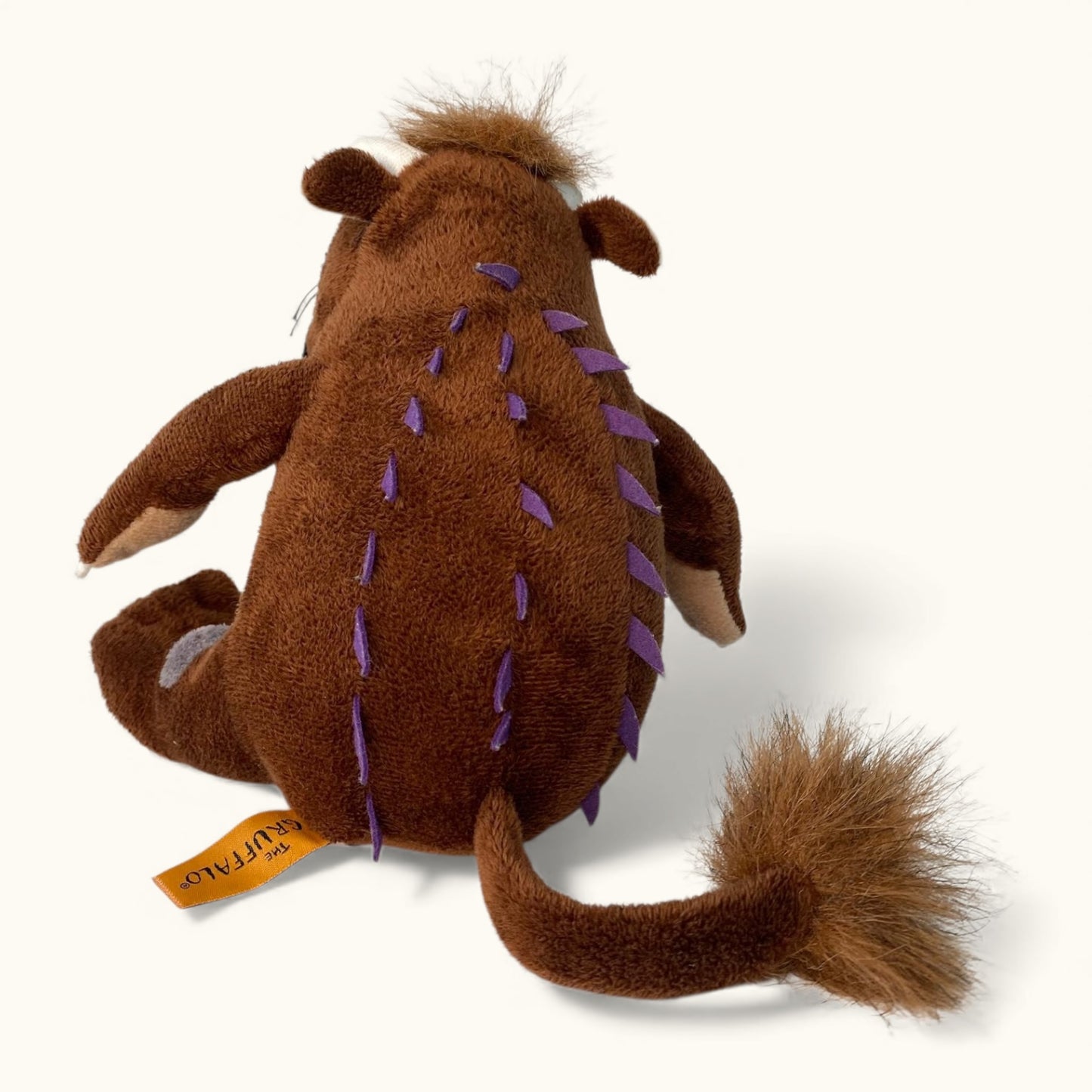 Brown plush toy with purple accents on a white background