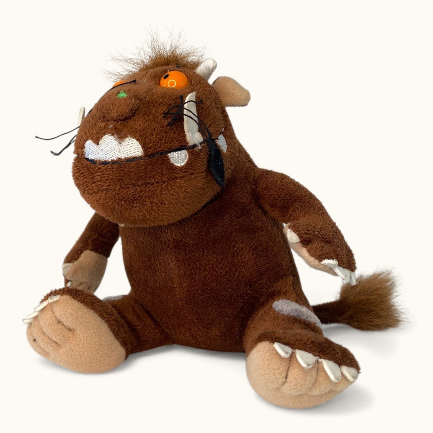 Plush toy of a brown creature with a white mouth on a white background