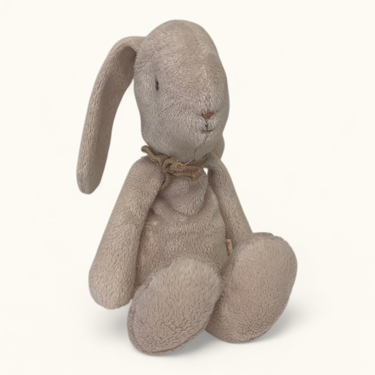 Stuffed rabbit toy with a bow tie on a white background