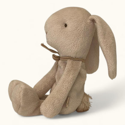 Beige plush bunny toy with a brown bow on a white background