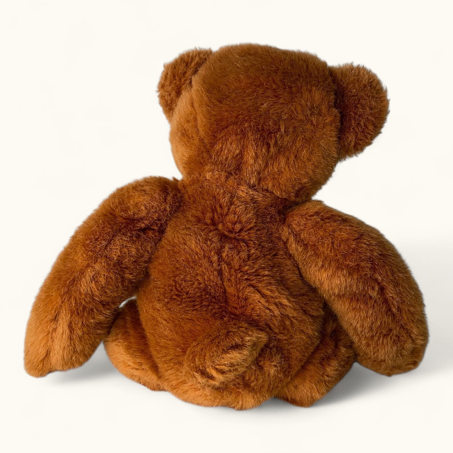 Brown teddy bear from behind on a white background