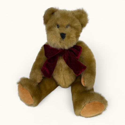 Brown teddy bear with a red bow tie on a white background