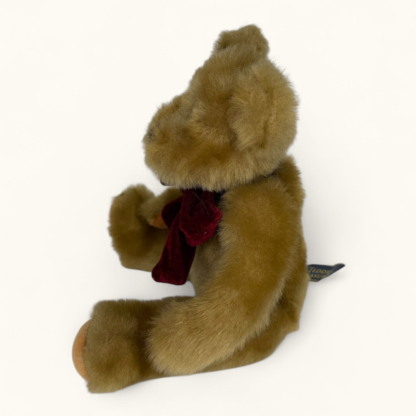 Brown teddy bear with a red bow tie on a white background