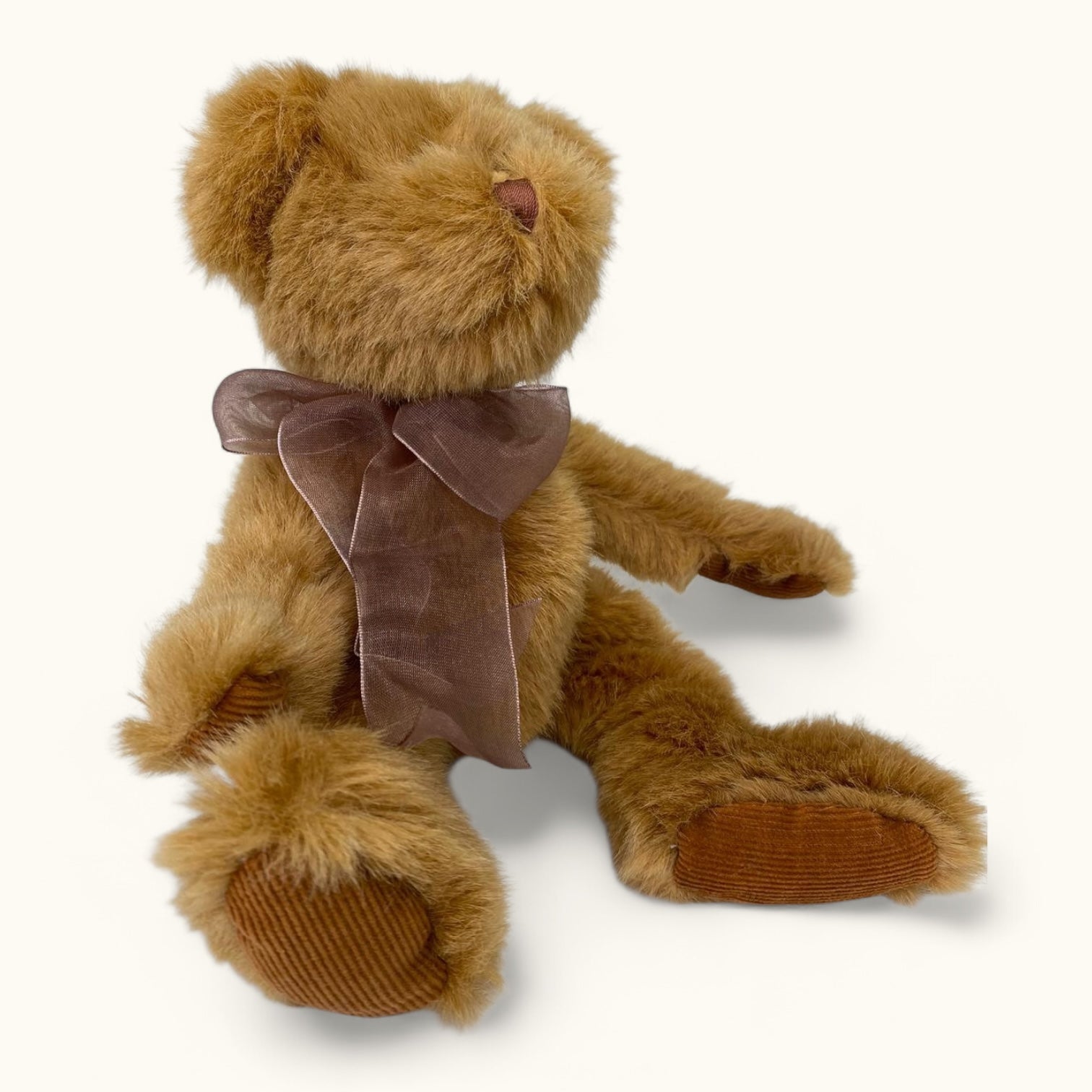 Brown teddy bear with a brown bow on a white background