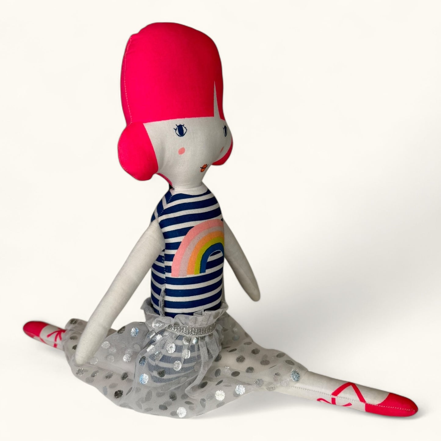 Stuffed doll with red hair, striped shirt, and polka dot skirt on a white background