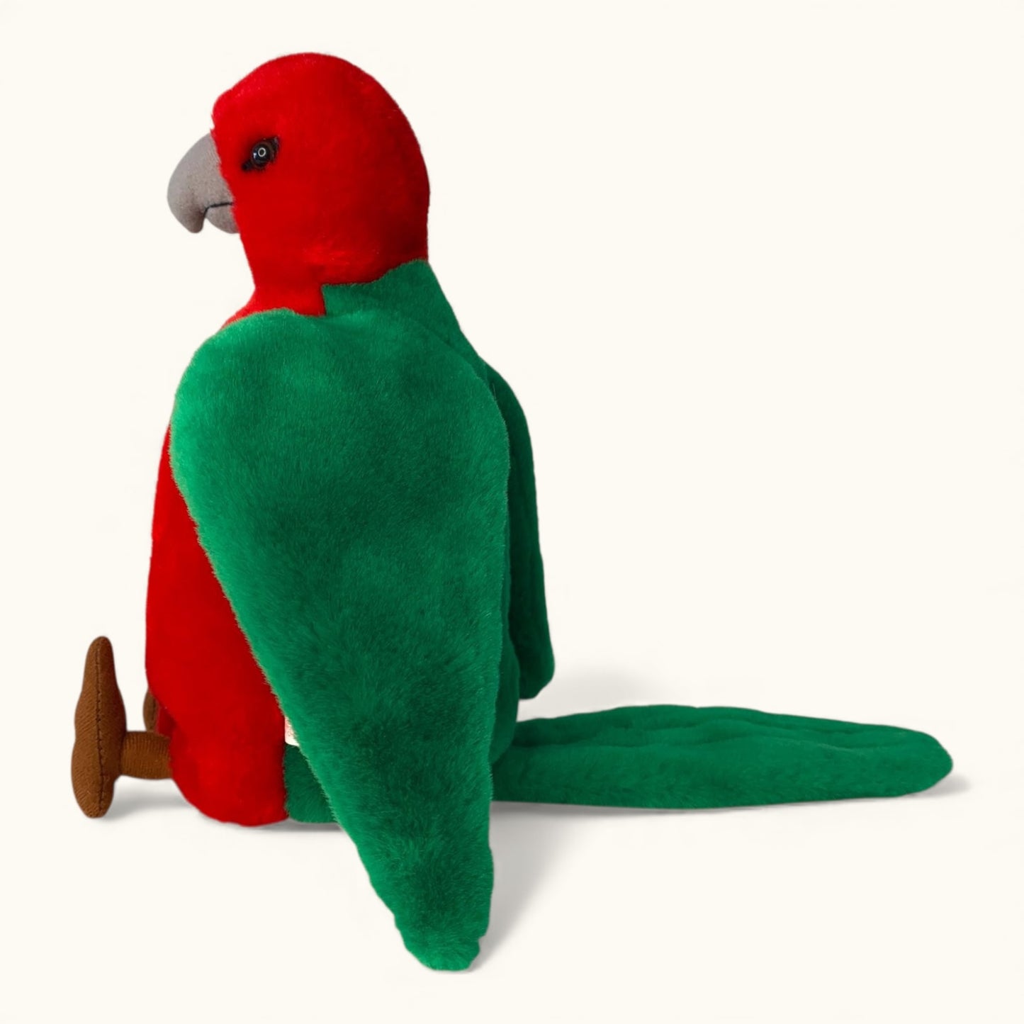 Red and green plush parrot toy on a white background