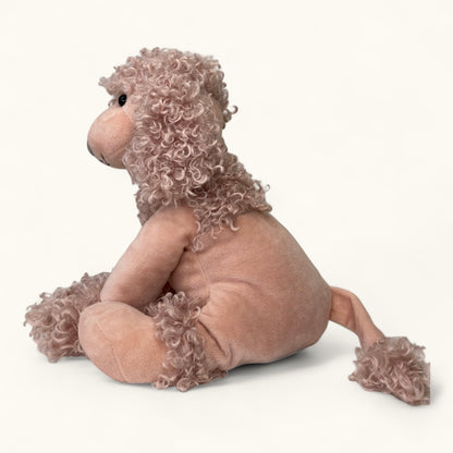 Plush toy dog poodle with curly fur on a white background