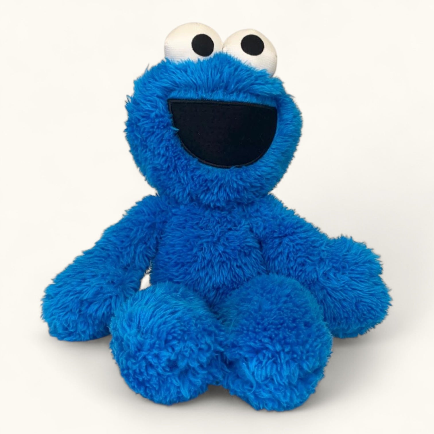 Blue plush toy with a smiling face on a white background