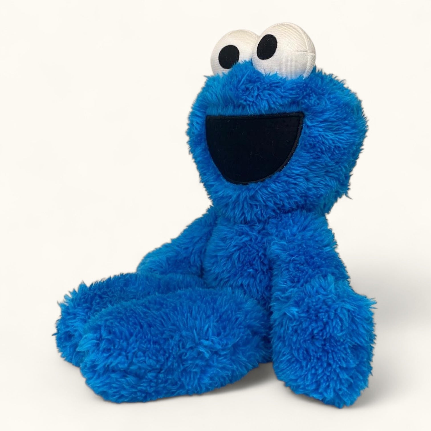 Blue plush toy with a smiling face on a white background