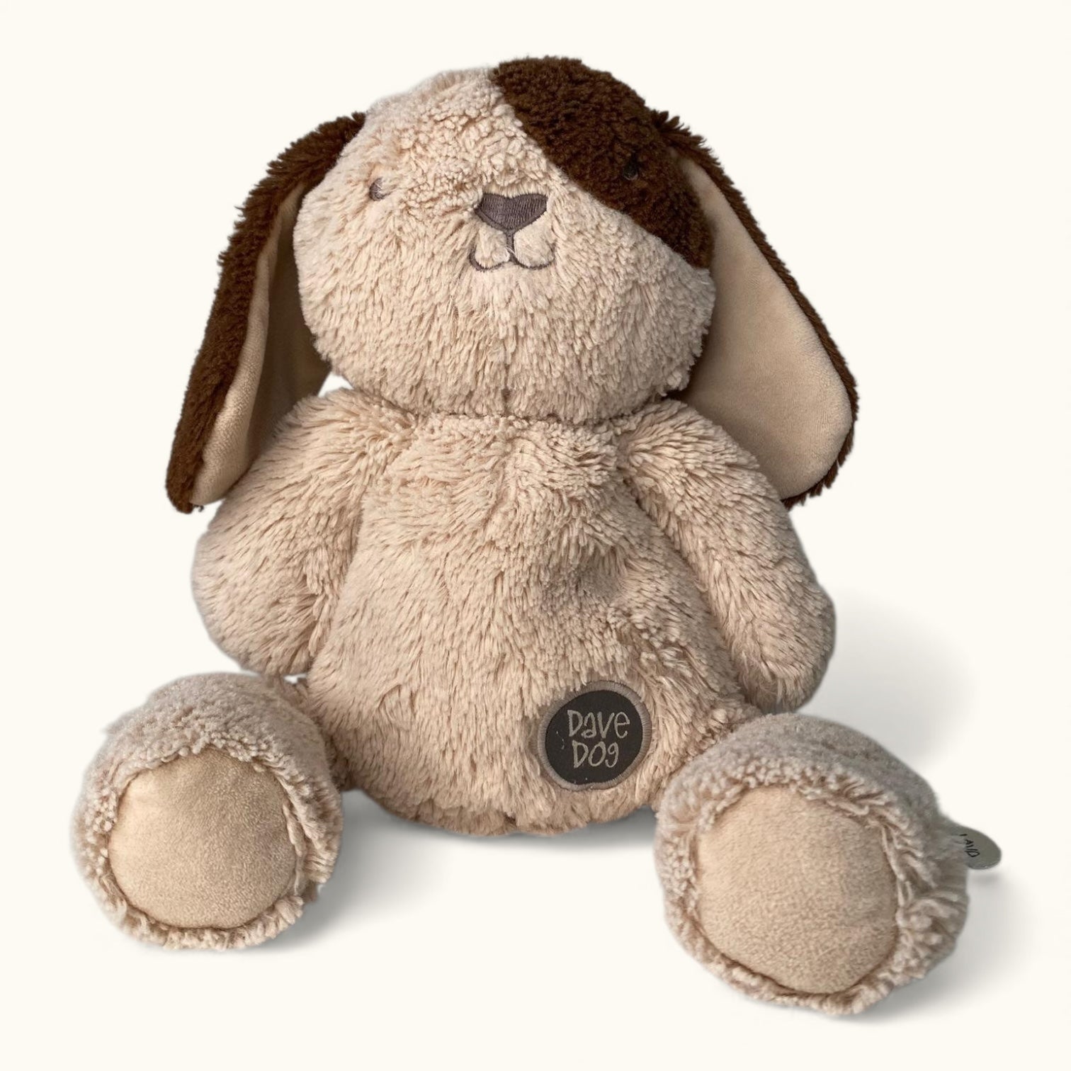 Plush toy dog with a brown nose on a white background