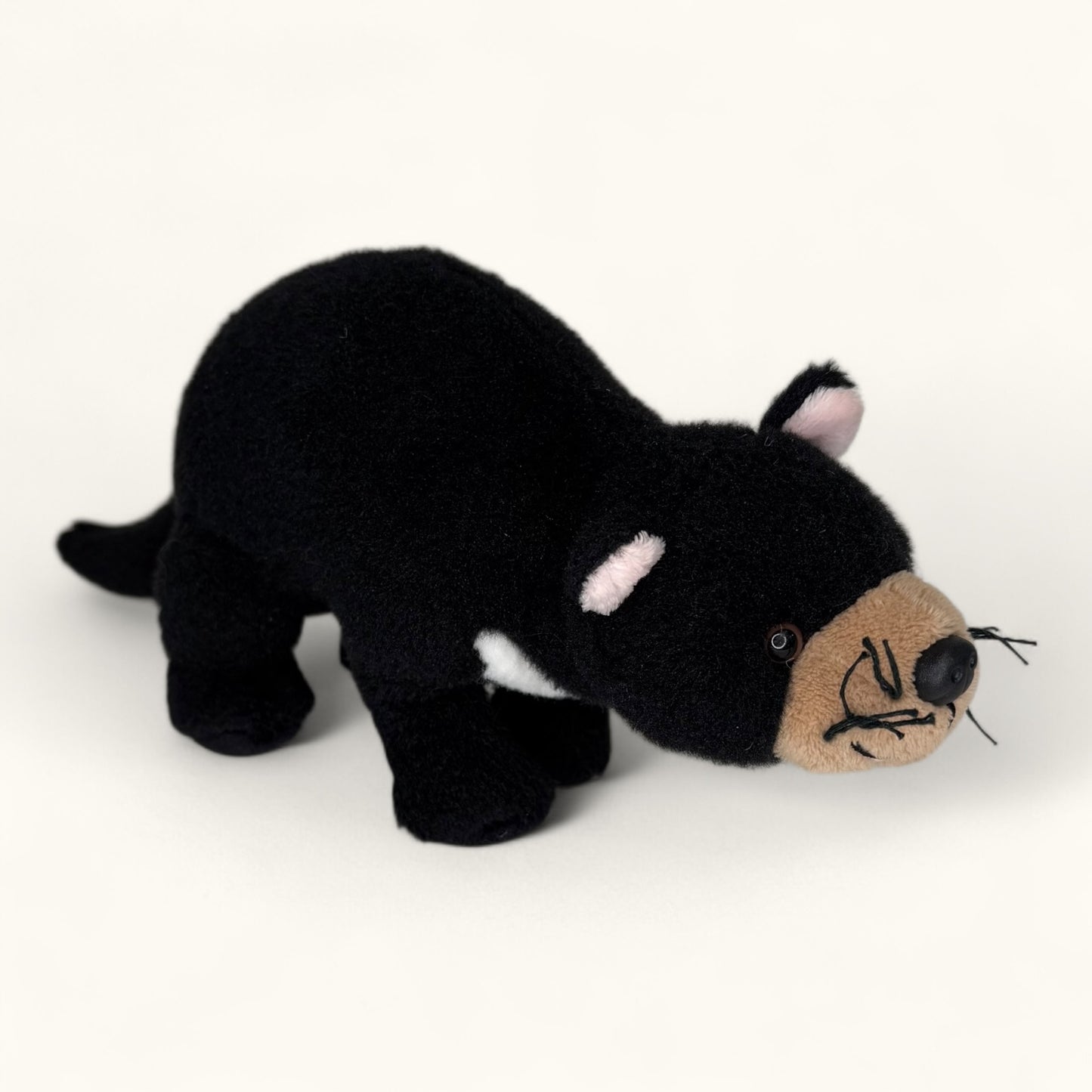 Black plush toy Tasmanian devil on a white background