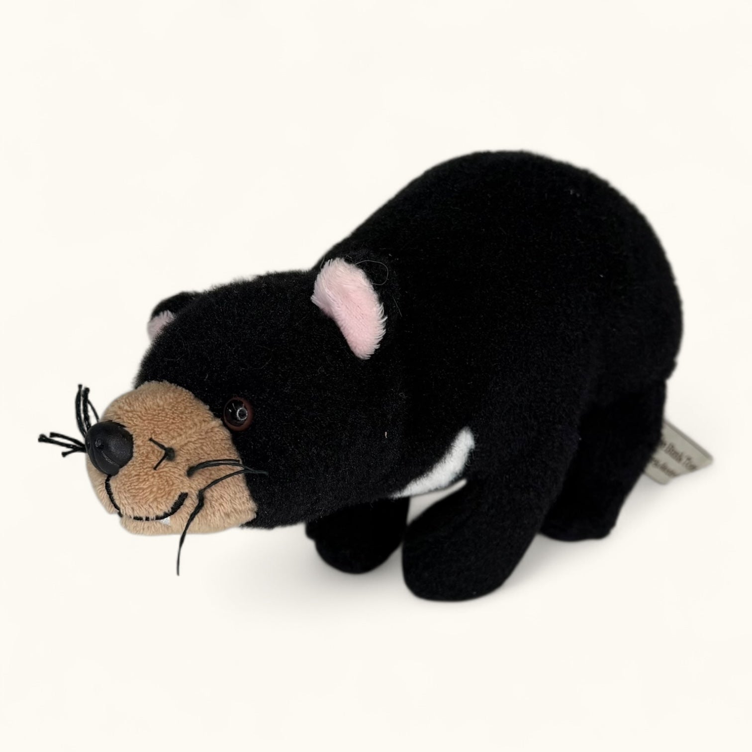 Black plush toy resembling a Tasmanian devil  on a white background