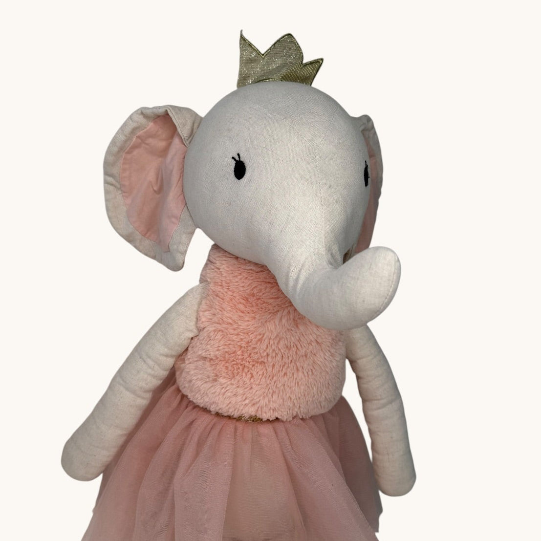 Plush elephant toy with a pink dress and tiara on a white background