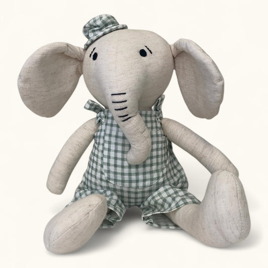 Stuffed elephant toy with a checkered outfit on a white background