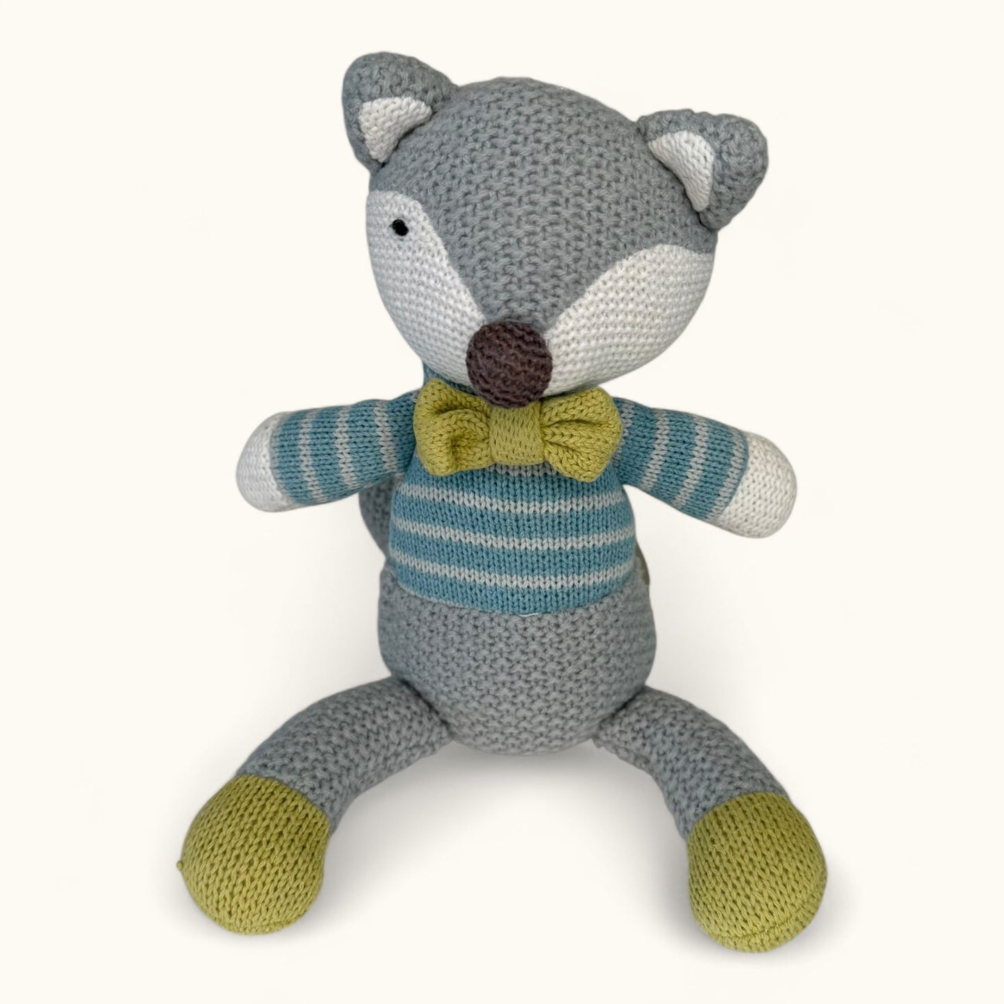Knitted fox toy with a striped sweater and bow tie on a white background