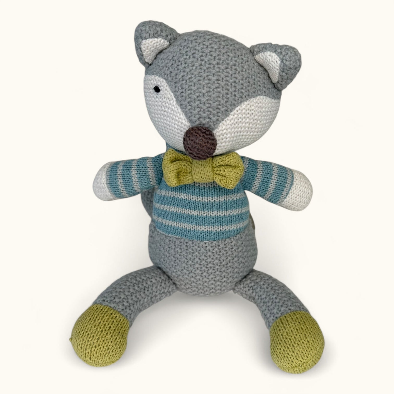 Knitted fox toy with a striped sweater and bow tie on a white background