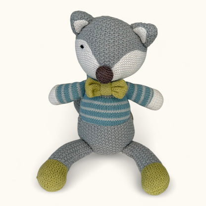 Knitted fox toy with a striped sweater and bow tie on a white background