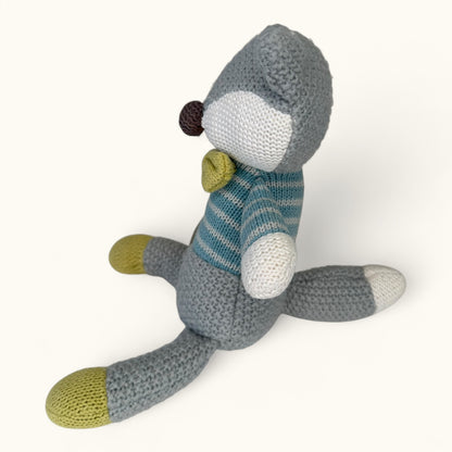 Knitted toy resembling a fox with a striped sweater on a white background