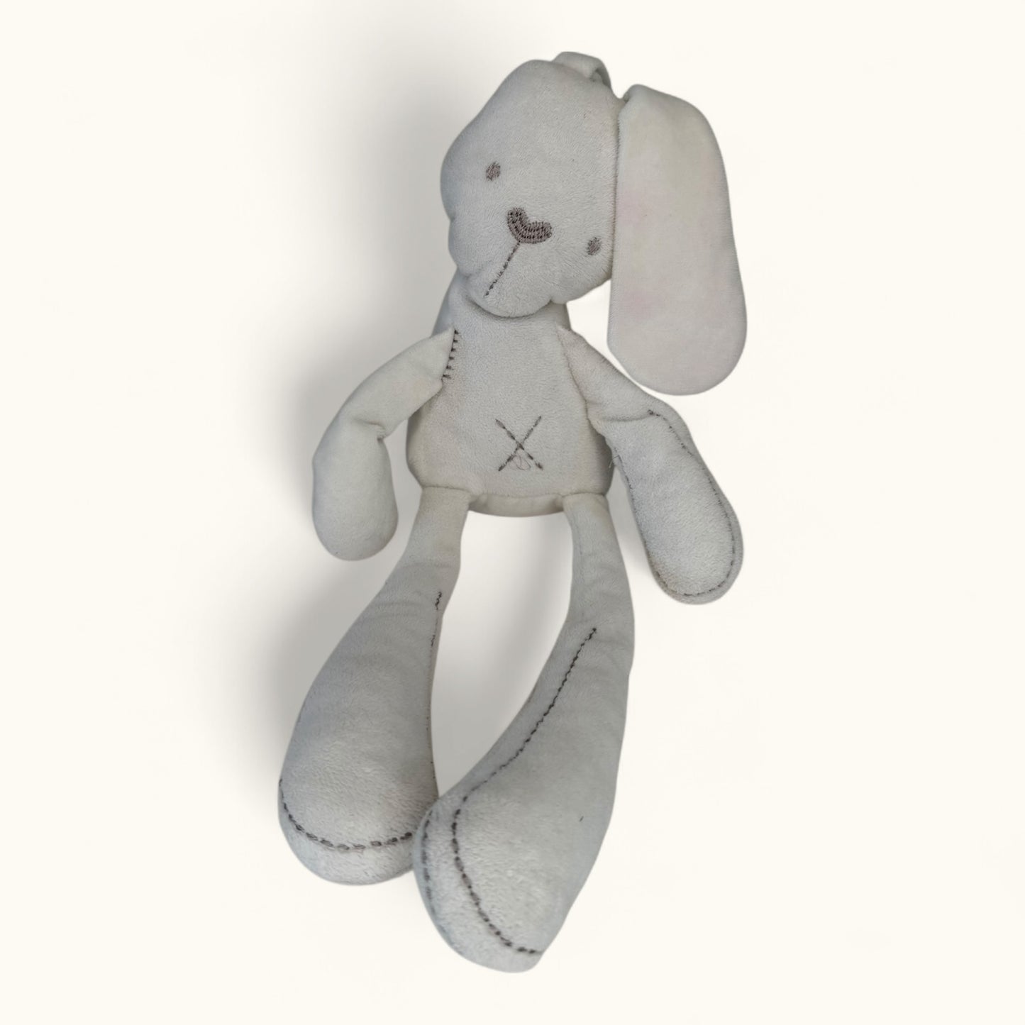 Gray stuffed bunny toy with a visible brand logo on a white background