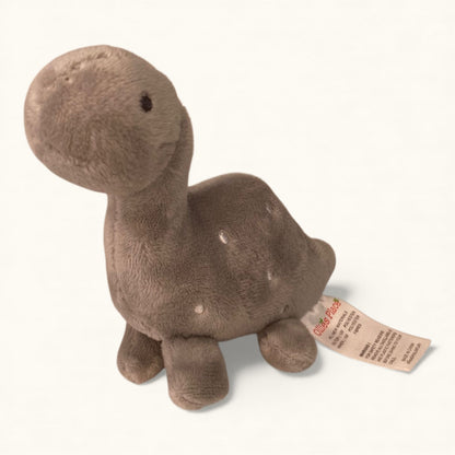 Plush dinosaur toy with a tag on a white background