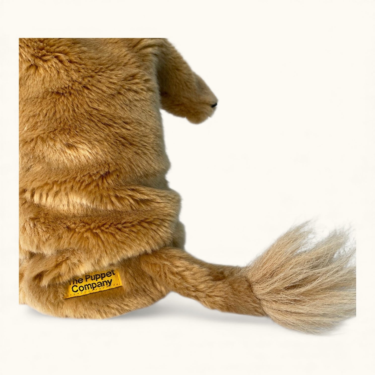 Plush lion toy with a visible brand label on a white background