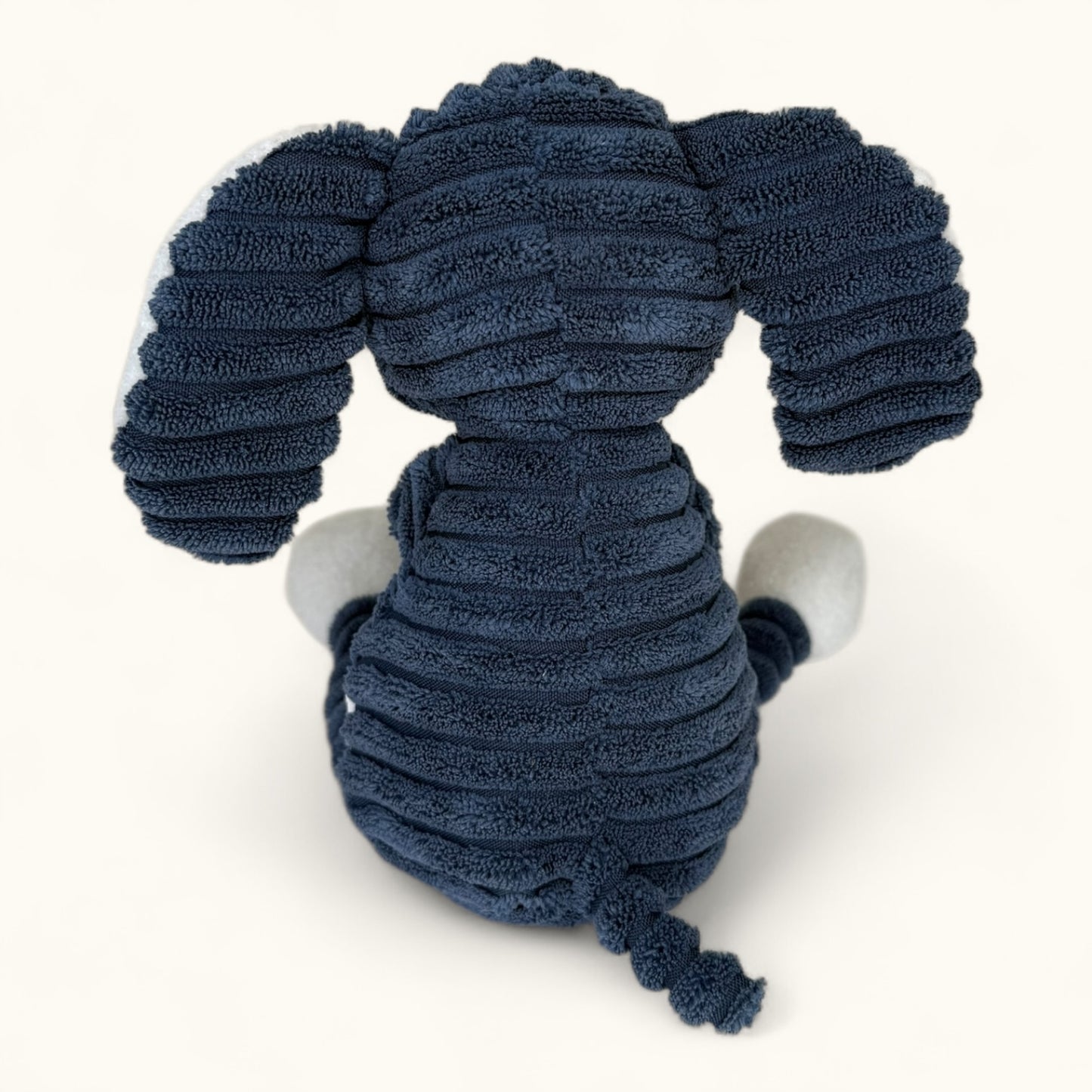 Blue plush elephant toy with white paws on a white background