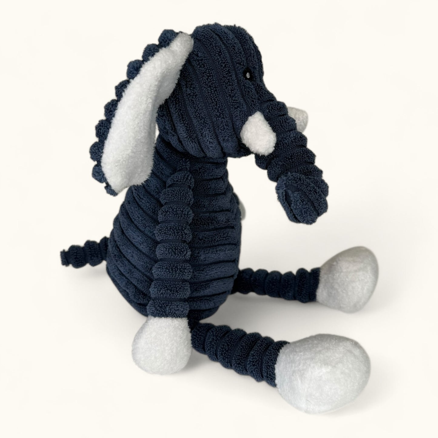 Navy blue and white plush elephant toy on a white background
