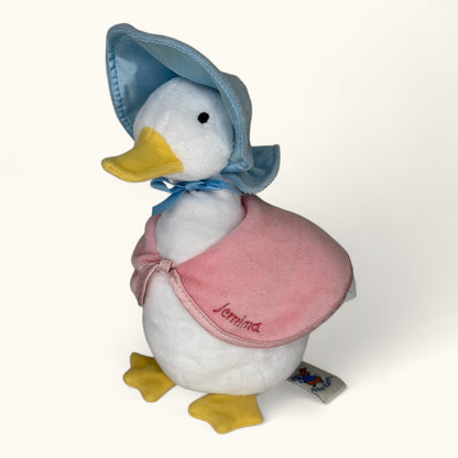 Plush duck toy with a blue bonnet and pink apron on a white background