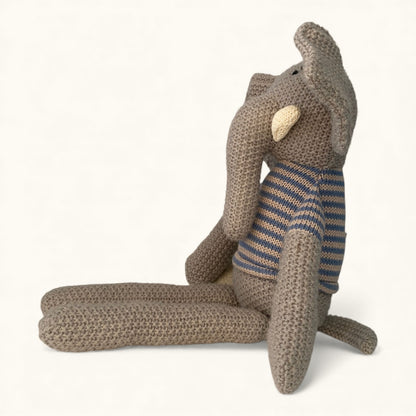 Knitted elephant toy with a striped sweater on a white background