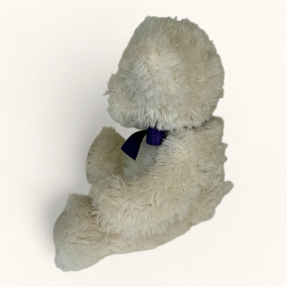 Plush toy teddy bear with a blue bow tie on a white background