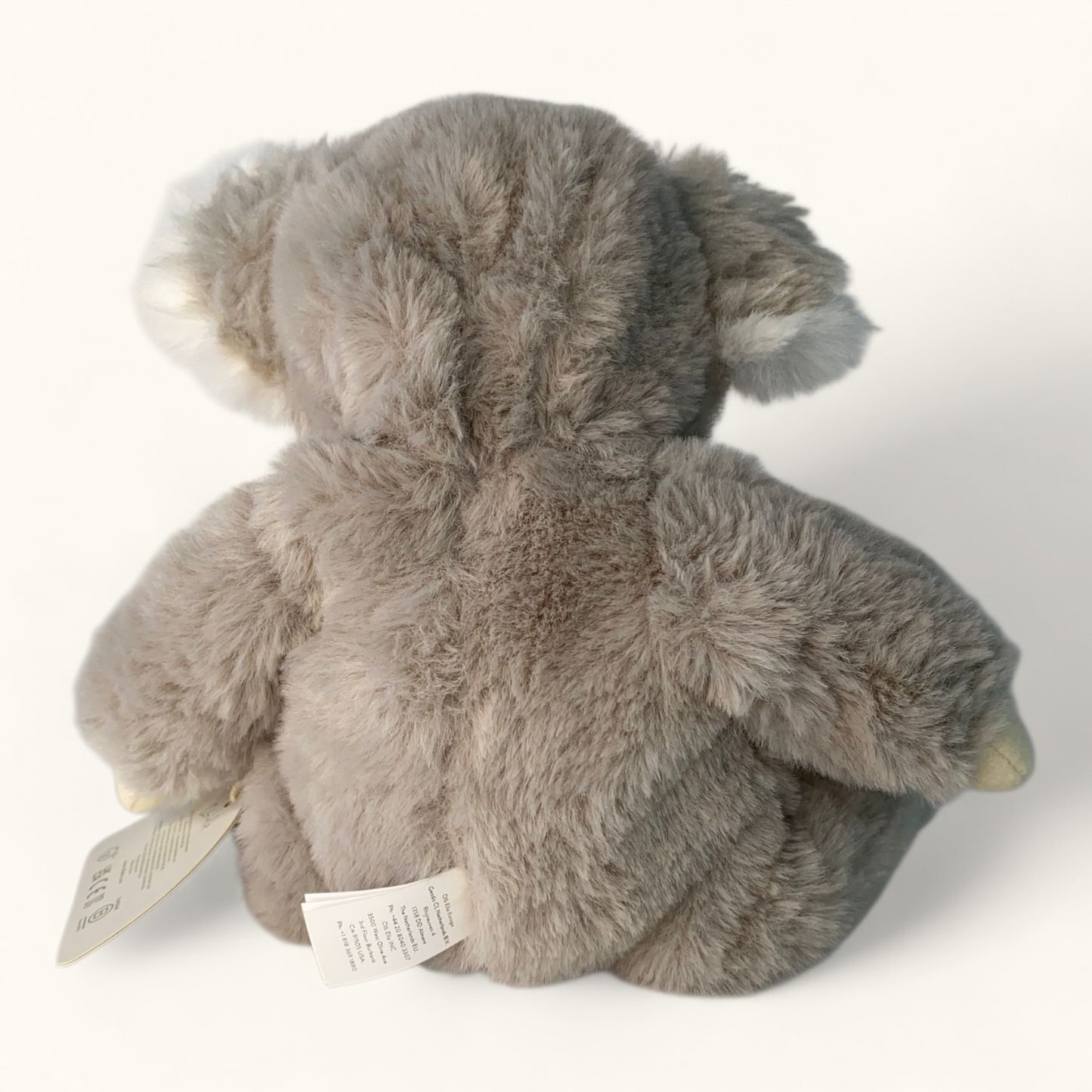 Gray plush koala bear toy with a tag on a white background