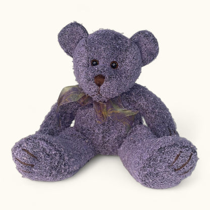 Purple teddy bear with a bow tie on a white background