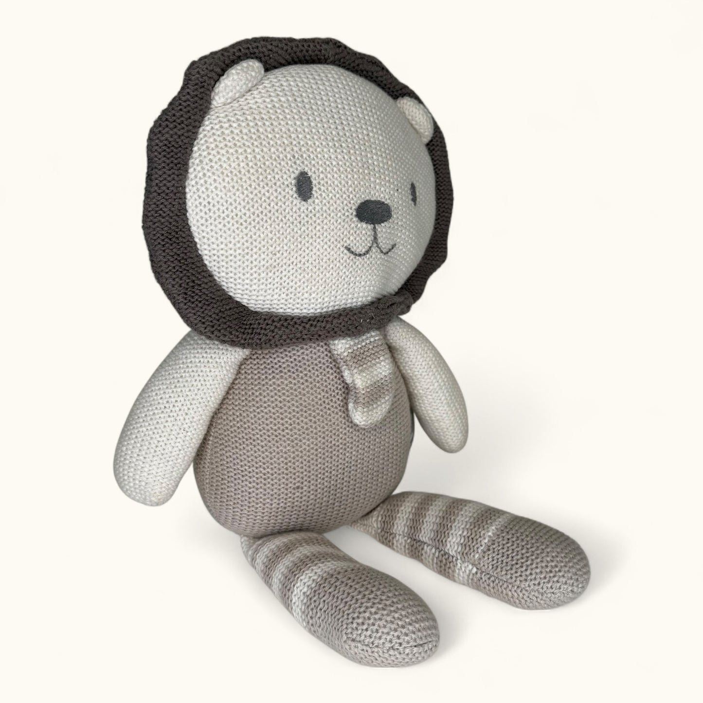 Knitted toy bear with a lion head on a white background