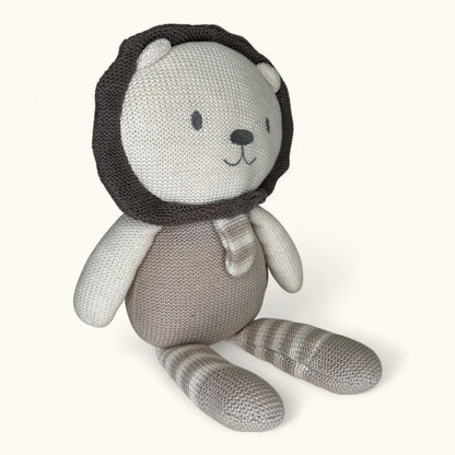 Knitted toy bear with a lion head on a white background