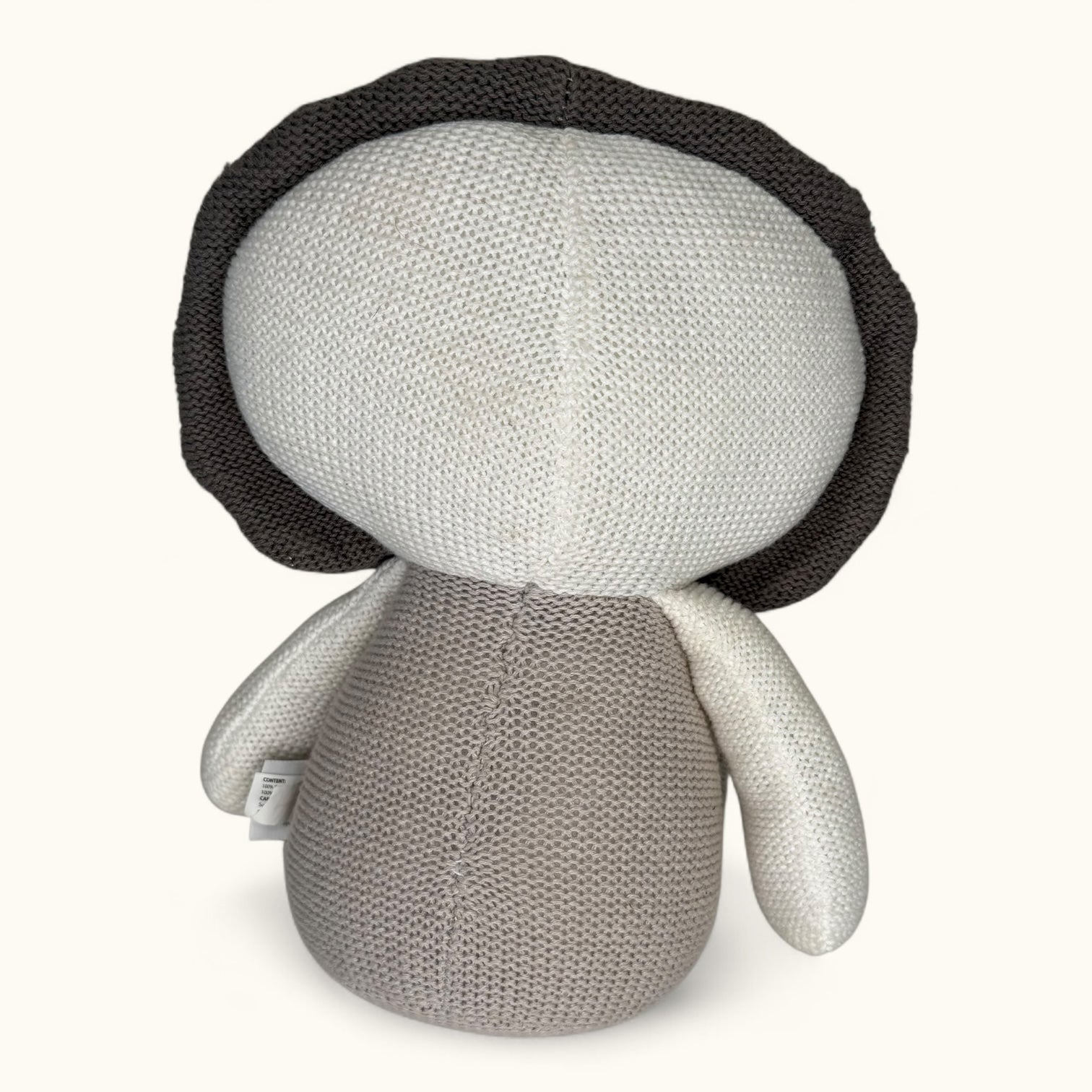 Knitted doll with a black hat on a white background