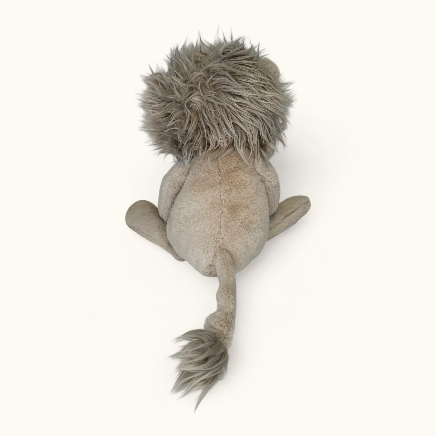Plush lion toy from behind on a white background