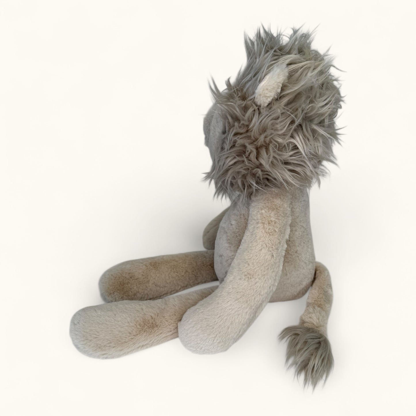 Plush lion toy with a fluffy mane on a white background