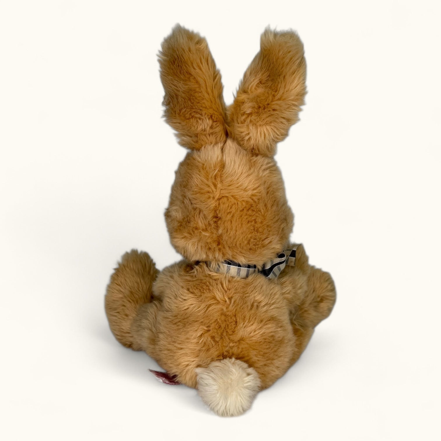 Brown plush bunny with a bow tie on a white background