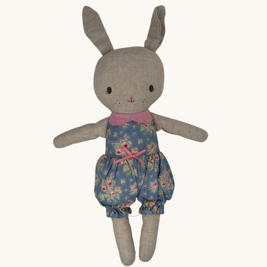Stuffed toy rabbit wearing a floral outfit on a white background