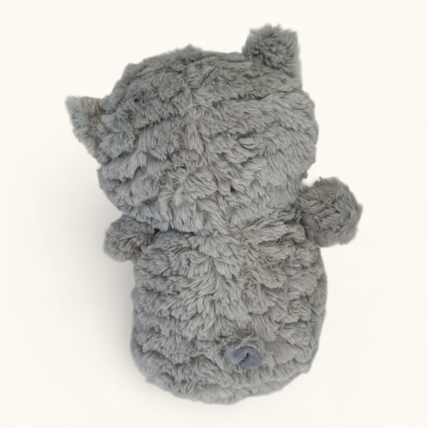 Gray plush toy resembling an owl on a white background