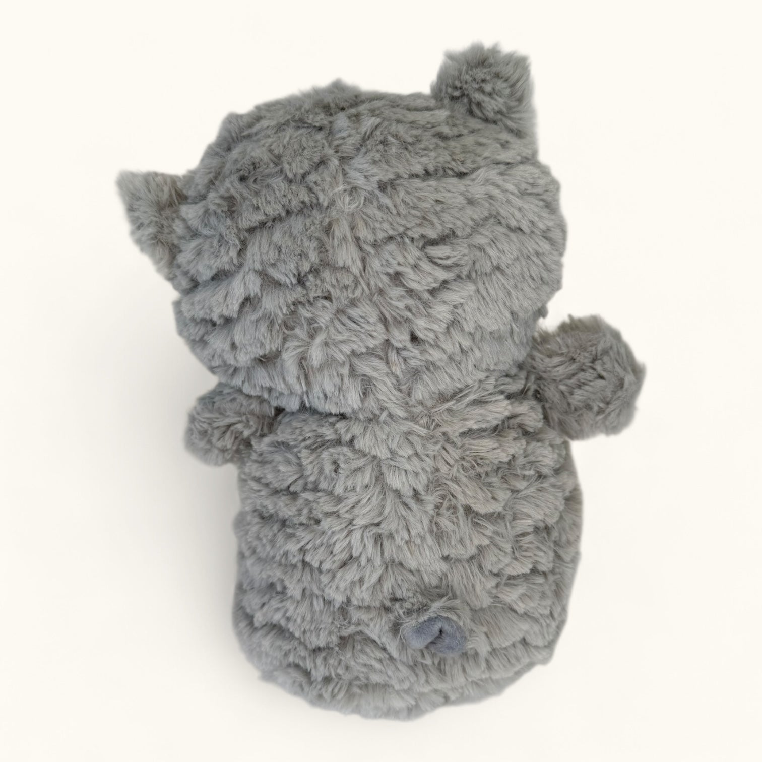Gray plush toy resembling an owl on a white background