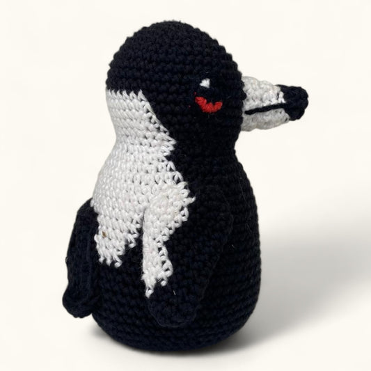 Crocheted penguin toy on a white background