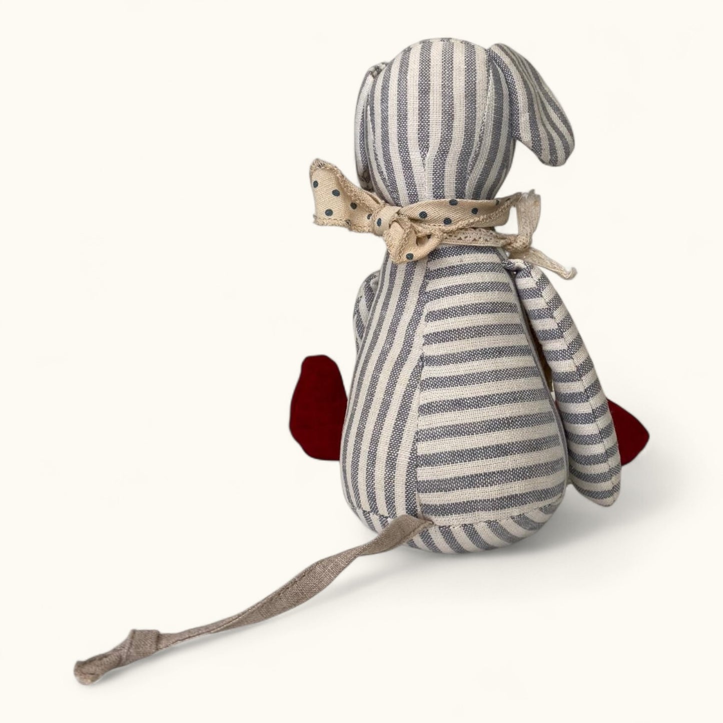 Striped toy mouse with a bow on a white background