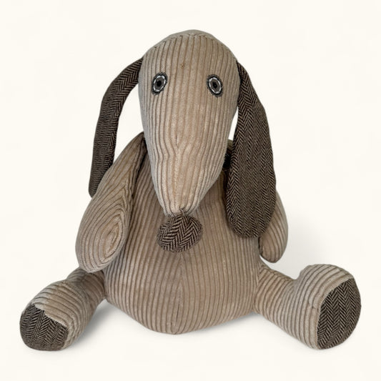 Stuffed dog toy with brown and beige ribbed texture on a white background